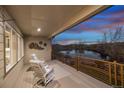 Relaxing covered patio with comfortable seating and a peaceful view of the serene lake at sunset at 12371 Red Fox Way, Broomfield, CO 80021