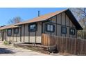 Tan and green trimmed home with a wooden fence and landscaped yard at 4710 E Louisiana Ave, Denver, CO 80246