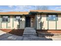 A front entryway with brown mulch landscaping, concrete stairs, and an exterior door with a screen at 4710 E Louisiana Ave, Denver, CO 80246