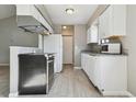 Well-lit kitchen featuring white cabinetry, granite countertops, and modern appliances at 4710 E Louisiana Ave, Denver, CO 80246