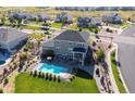 Aerial view of a backyard with a pool, patio with seating and a well-maintained lawn at 23230 E Rockinghorse Pkwy, Aurora, CO 80016