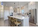 Bright kitchen featuring white cabinetry, stainless steel appliances, and a large island with seating at 23230 E Rockinghorse Pkwy, Aurora, CO 80016