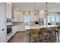 Modern kitchen with white cabinets, stainless steel appliances, and a large central island at 23230 E Rockinghorse Pkwy, Aurora, CO 80016