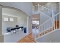 Spacious foyer featuring hardwood floors, a staircase, and an office area flooded with natural light at 8641 Coors St, Arvada, CO 80005