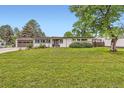 Charming single-story home with a well-maintained lawn, mature trees, and a two-car garage at 845 Everett St, Lakewood, CO 80215
