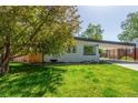 Charming home with lush front yard and covered parking offers great curb appeal at 1570 S Chase St, Lakewood, CO 80232