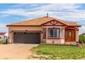 Lovely tan home featuring a brown garage door and red trim details at 46303 E 106Th Ave, Bennett, CO 80102