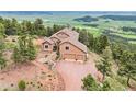 Aerial view of secluded mountain home surrounded by lush trees and spectacular views at 13084 Deer Ridge Way, Larkspur, CO 80118