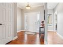 Bright entryway featuring hardwood floors, a white front door with sidelights, and neutral wall paint at 13084 Deer Ridge Way, Larkspur, CO 80118