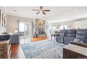 Open living room features a stone fireplace, hardwood floors, and sliding glass doors to the outdoors at 13084 Deer Ridge Way, Larkspur, CO 80118