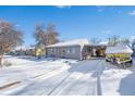 House exterior and driveway covered in snow, with a boat parked nearby at 2220 S Linley Ct, Denver, CO 80219