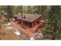 Stunning elevated view of a charming home with a spacious deck and inviting outdoor seating at 28630 Pine Dr, Evergreen, CO 80439