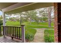 Inviting front porch with views of the lush green lawn, mature trees, and neighborhood at 7409 E Jamison Dr, Centennial, CO 80112