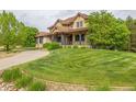 Expansive front yard with lush lawn and mature trees surrounding an elegant residence at 14154 Lexington Cir, Westminster, CO 80023