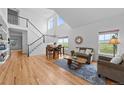 Bright living room with hardwood floors, large windows, and a staircase at 9105 W Freiburg Pl, Littleton, CO 80127