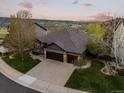 Beautiful sunset aerial view of house with well-kept lawn and trees, nestled within a scenic landscape at 828 Rabbit Run Dr, Golden, CO 80401