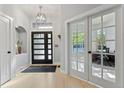 Bright entryway with modern light fixture, decorative niche, and glass french doors that offer a view of an office at 828 Rabbit Run Dr, Golden, CO 80401