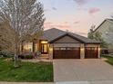 Charming single Gathering home with a three-car garage, stone accents, and manicured lawn at 828 Rabbit Run Dr, Golden, CO 80401