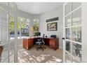 Sunlit office with large windows, hardwood floors, and a comfortable workspace, perfect for remote work or study at 828 Rabbit Run Dr, Golden, CO 80401