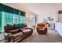 Relaxing living room with brown leather furniture and large window at 4460 S Jebel Ln, Centennial, CO 80015