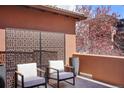 Outdoor balcony featuring modern chairs, privacy screen, and potted plants with neighborhood views at 15314 W Baker Ave, Lakewood, CO 80228