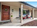 Inviting front porch features decorative door, seating area, and brick exterior for a cozy welcome at 3194 S Milwaukee St, Denver, CO 80210