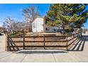 A charming home with a well-kept yard, decorative rock wall, and a classic wooden fence at 7815 Conifer Rd, Denver, CO 80221