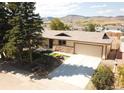 Expansive exterior of a single-story home with mature trees, landscaping, and mountain views at 6147 Dunraven, Golden, CO 80403