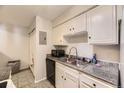 Galley kitchen with stainless steel sink, granite countertops and white cabinetry at 4653 S Lowell Blvd # E, Denver, CO 80236