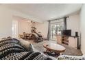 Cozy living room with a sliding glass door leading to a balcony and comfortable furnishings at 4653 S Lowell Blvd # E, Denver, CO 80236