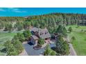 Beautiful home with a large yard and mature trees offering a private and serene setting at 3842 Estates Cir, Larkspur, CO 80118