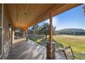 Covered back porch with stone columns offers scenic views of the surrounding landscape at 3842 Estates Cir, Larkspur, CO 80118