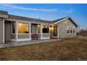 Home featuring gray siding, updated windows, and outdoor seating on a paver patio at 44011 Morning Star Ct, Elizabeth, CO 80107