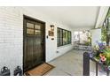 Charming front porch featuring a dark wood door, black-framed windows, and stylish outdoor decor at 474 S Vine St, Denver, CO 80209