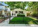 Charming home featuring a well-manicured lawn, black fencing, and an inviting front porch with garden accents at 474 S Vine St, Denver, CO 80209