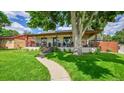 Charming single-story home featuring a welcoming front porch and lush green lawn at 2990 S Sherman St, Englewood, CO 80113