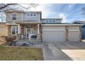 Two-story home features a three-car garage and stone accents, enhanced by a well-kept lawn at 4950 Mt Cameron Dr, Brighton, CO 80601