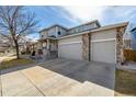 Charming two-story home with a three-car garage, stone accents, and well-maintained landscaping at 4950 Mt Cameron Dr, Brighton, CO 80601