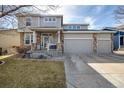 Charming two-story home features a three-car garage, inviting porch, and stone pillar accents at 4950 Mt Cameron Dr, Brighton, CO 80601