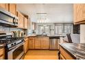 Well-lit kitchen featuring stainless steel appliances, granite countertops, and an open view to the living area at 4666 Cornish Way, Denver, CO 80239