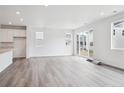 Open-concept living room with wood-look flooring, ample natural light, and sliding glass doors at 45922 Gentry Ave, Bennett, CO 80102