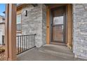 Welcoming entryway with stone accents, front door, and small front porch at 1820 Ghost Dance Cir, Castle Rock, CO 80108