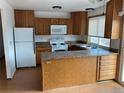 Functional kitchen with wood cabinets, an island counter, stainless steel appliances, and lots of natural light at 16390 E Bates Dr, Aurora, CO 80013