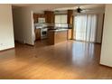 Open-concept living and dining area with wood floors, bright natural light, and a view into the kitchen at 16390 E Bates Dr, Aurora, CO 80013