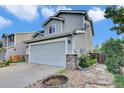 Charming home with a two-car garage featuring stone accents and mature landscaping at 9595 Marmot Ridge Cir, Littleton, CO 80125