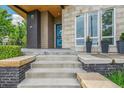 Welcoming front entrance with stone steps and a vibrant blue door at 9244 E 37Th Ave, Denver, CO 80238