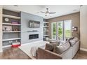 Comfortable living room with built-in shelves, modern fireplace, and large sectional sofa at 9244 E 37Th Ave, Denver, CO 80238