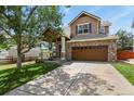 Charming two-story home showcasing a well-maintained front yard, inviting porch, and a brick two-car garage at 3912 Miners Candle Pl, Castle Rock, CO 80109