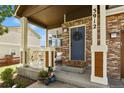 Inviting front porch features stylish railing, a wreath on the front door, and beautiful potted flowers at 3912 Miners Candle Pl, Castle Rock, CO 80109