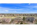 Expansive aerial view featuring the neighborhood's layout with houses nestled within a green landscape under a bright sky at 11065 W Rockland Dr, Littleton, CO 80127